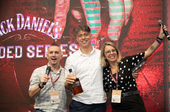 Employees celebrating and holding bottles of Jack Daniel's at an awards ceremony