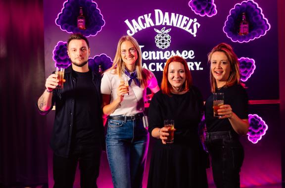 Employees toasting with a Jack Daniel's Blackberry banner in background